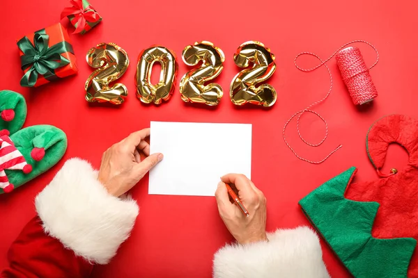 サンタクロースは 赤い背景に図2022の形で空白の紙シートと風船で — ストック写真