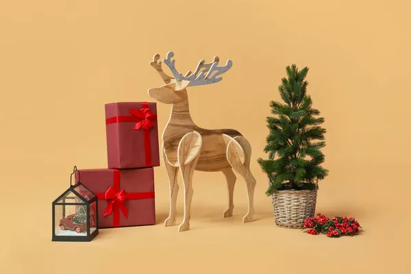 木のトナカイとクリスマスツリーとベージュの背景にプレゼント — ストック写真