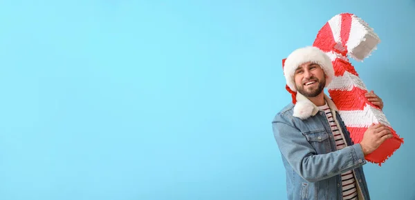 Schöner Mann Mit Weihnachtsmütze Und Zuckerstange Pinata Auf Blauem Hintergrund — Stockfoto