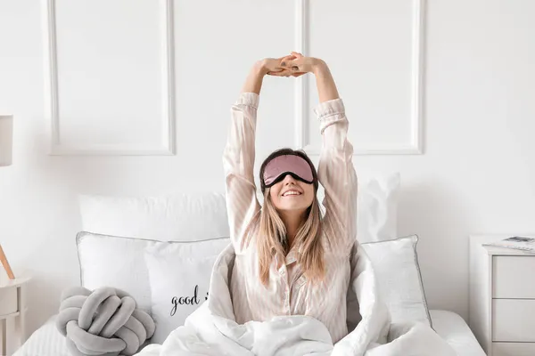 Jonge Vrouw Met Slaapmasker Stretching Bed — Stockfoto