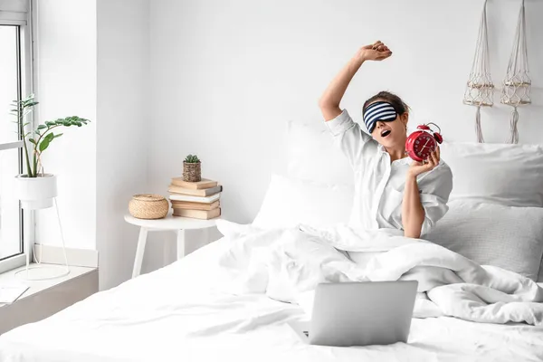 Morning Young Woman Sleeping Mask Alarm Clock Laptop Stretching Bed — Stock Photo, Image