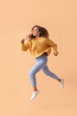 Renkli arka planda atlayan genç Afro-Amerikan kadın