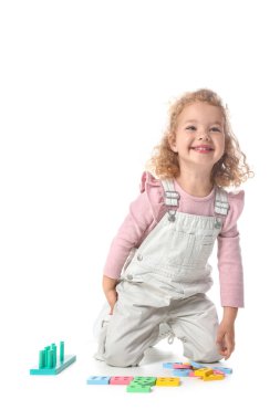 Beyaz arka planda oyuncaklarla oynayan tatlı bir kız.