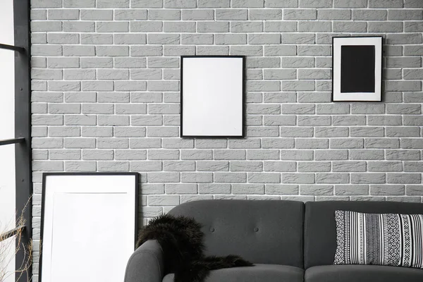 Blank Picture Frames Grey Sofa Brick Wall Background — Stock Photo, Image