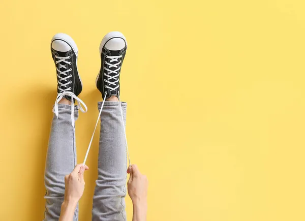 Mujer Zapatillas Atando Cordones Blancos Sobre Fondo Amarillo — Foto de Stock