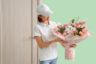 Koridorda bir buket çiçekli kadın kurye.