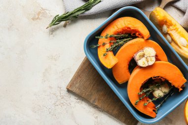 Hafif arka planda balkabağı parçaları olan fırın tabağı.