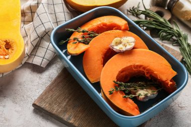 Hafif arka planda balkabağı parçaları olan fırın tabağı.