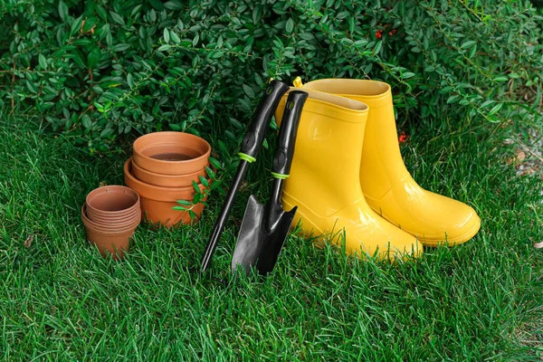 户外绿草上的园艺工具和靴子 — 图库照片