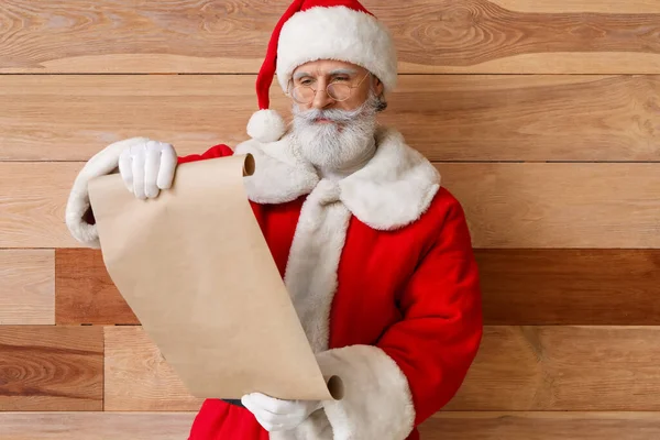 Санта Клаус Читает Письмо Деревянном Фоне — стоковое фото