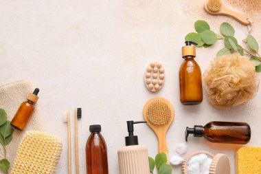 Lif süngerli banyo malzemeleri ve beyaz arka planda bitki dalları.