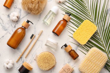 Süngerli banyo malzemeleri ve arka planda palmiye yaprağı.