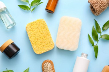 Mavi arka planda süngerli banyo malzemeleri.