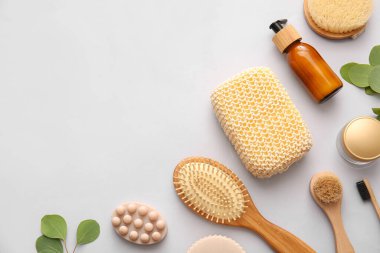 Süngerli banyo malzemeleri ve hafif arka planda fırçalar.