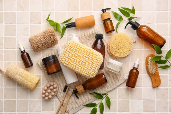 Süngerli banyo malzemeleri ve bej fayansların üzerine ağaç dalları.