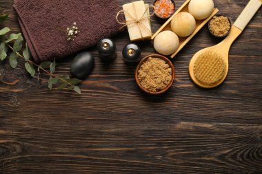 Koyu ahşap arka planda yanan mumlarla güzel bir spa kompozisyonu.