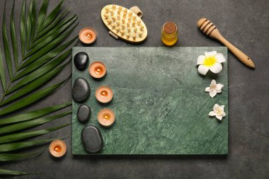 Koyu arkaplanda yanan mumlar ve palmiye yaprağı olan güzel bir spa kompozisyonu.