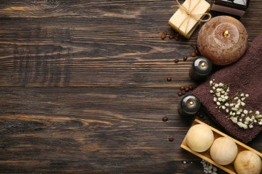 Koyu ahşap arka planda yanan mumlarla güzel bir spa kompozisyonu.