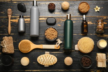 Koyu ahşap arka planda farklı doğal kozmetik ürünleri ve spa aksesuarları.