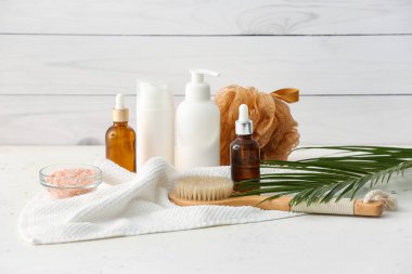 Hafif ahşap arka planda kozmetik şişeleriyle spa seti