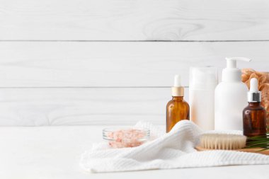 Hafif ahşap arka planda kozmetik şişeleriyle spa seti