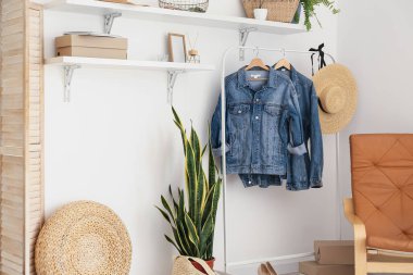 Modern koridorda ışık duvarının yanında kot ceketli raflar