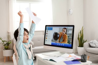 Evde okul sınavı için cevap kağıdı olan küçük bir çocuk.