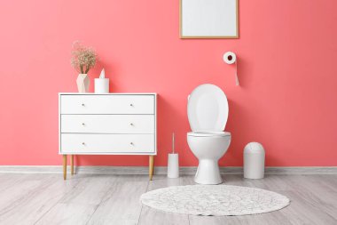 Pembe duvarlı modern tuvaletin içi.