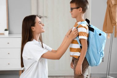 Anne oğlunu okula hazırlıyor.