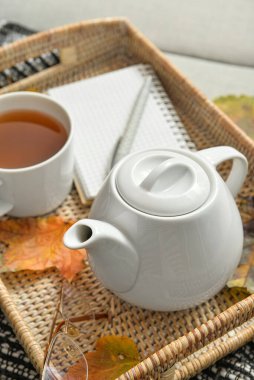 Kanepeye çay demliği koy.