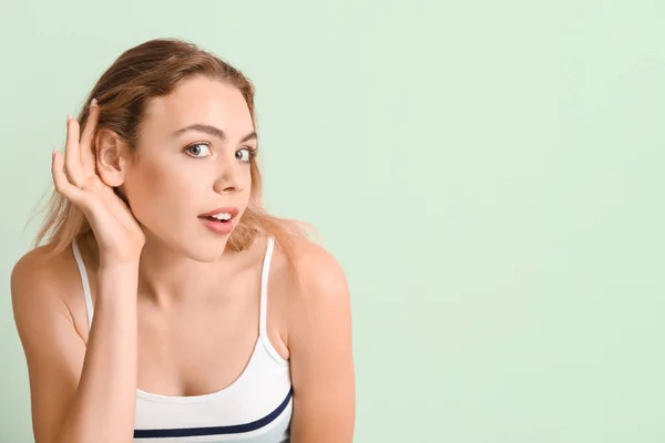 Mujer Joven Curiosa Tratando Escuchar Algo Sobre Fondo Color — Foto de Stock
