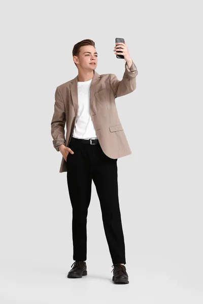 Teenager Mit Handy Macht Selfie Auf Weißem Hintergrund — Stockfoto