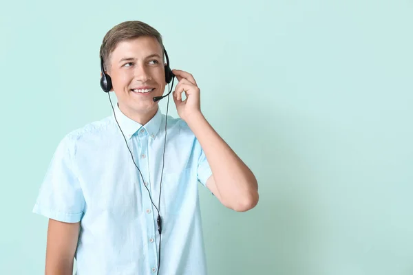 蓝色背景耳机呼叫中心的年轻顾问 — 图库照片