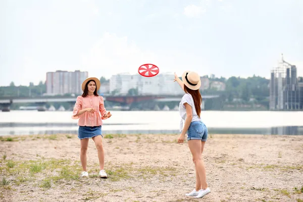 Smukke Unge Kvinder Spiller Frisbee Nær Floden - Stock-foto