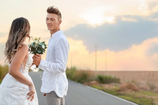 田舎の路上で幸せな結婚式のカップル — ストック写真