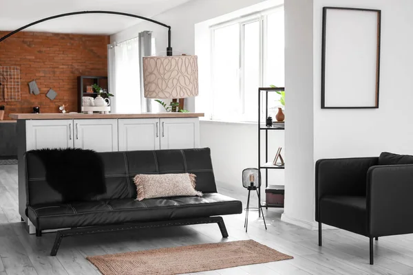 スタイリッシュなソファと現代的なキッチン付きのスタジオアパートメント — ストック写真