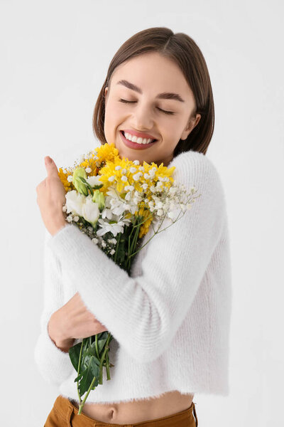 Красивая молодая женщина с букет цветов на белом фоне