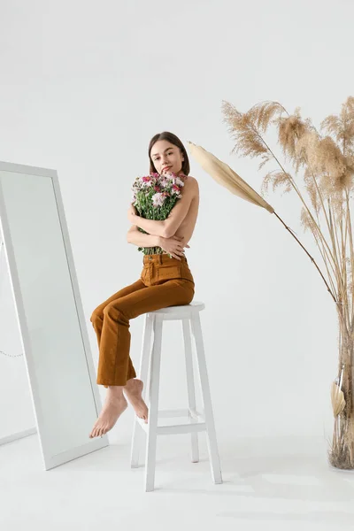 Sexig Ung Kvinna Med Bukett Blommor Sitter Stol Mot Ljus — Stockfoto