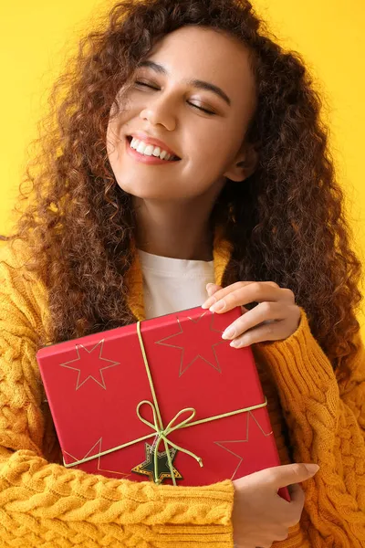 Young African American Woman Warm Sweater Christmas Present Yellow Background — Stock Photo, Image