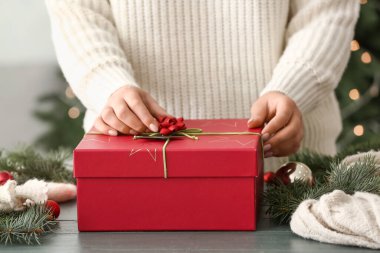 Masada güzel Noel hediye kutusunu dekore eden kadın, yakın plan.