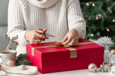 Masada güzel Noel hediye kutusunu dekore eden kadın, yakın plan.