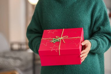 Odada güzel bir Noel hediyesi kutusu olan kadın, yakın plan.