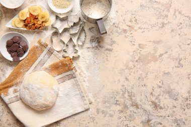 Bej arka planda ev yapımı kurabiyeler hazırlamak için taze hamur ve malzemeler
