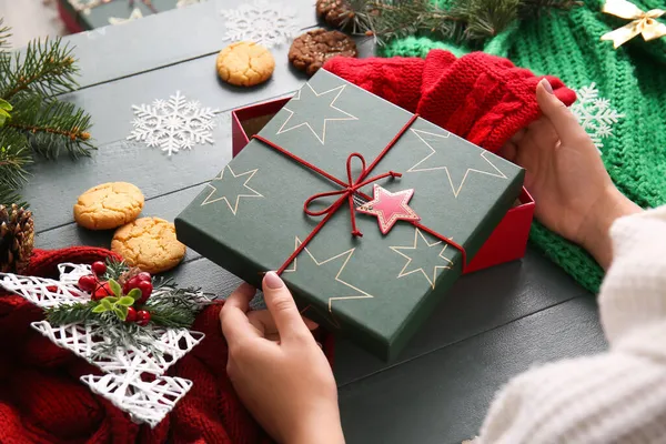 Mujer Poniendo Guantes Caja Regalo Navidad Mesa —  Fotos de Stock