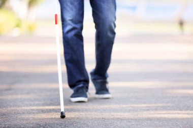 Dışarıda bastonu olan kör bir adam.