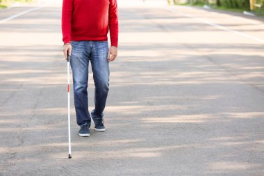 Dışarıda yürüyen kör yaşlı adam.