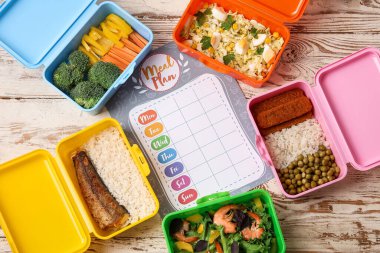 Konteynırlarda farklı sağlıklı yiyecekler ve hafif ahşap arka planda yemek planı.