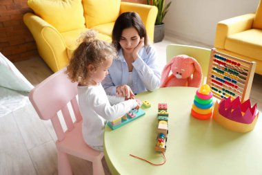 Sevimli kız ve annesi evde oynuyorlar.