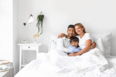 Küçük oğulları yatakta yatarken mutlu ebeveynler