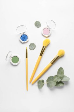 Beyaz arkaplanda makyaj fırçası olan dekoratif kozmetik seti